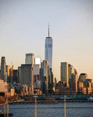 Zelfklevend Fotobehang Golden hour graces the Manhattan skyline, viewed from Little Island. © Aneesh Prodduturu