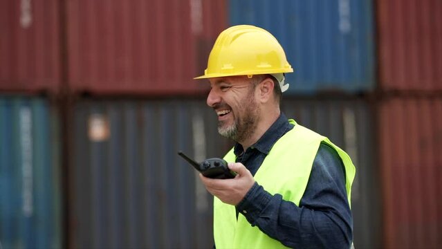 smiling container industry worker transporting import and export of goods to shipping business organizing team with his walkie talkie