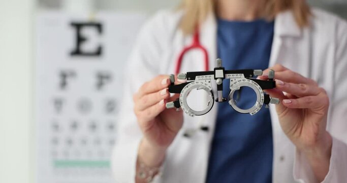 Ophthalmologist holds glasses in hands to select lenses for patient