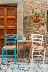 Two chairs and a table outdoor bar in a medieval Italian countryside.