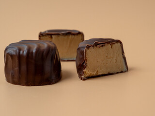 Chocolate candies on an orange background. Chocolate candies close-up.