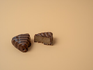 Chocolate candies on an orange background. Chocolate candies close-up.
