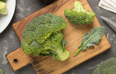 Fresh tasty broccoli on concrete background, top view