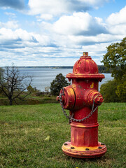 A vibrant, red water post on the lawn at Fort Washington, Virginia, overlooking the Potomac River and the inlet to the Capital Washington D.C.