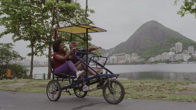Casal de meia idade se preparando para um passeio de triciclo a beira-mar. Cinematico 4k.