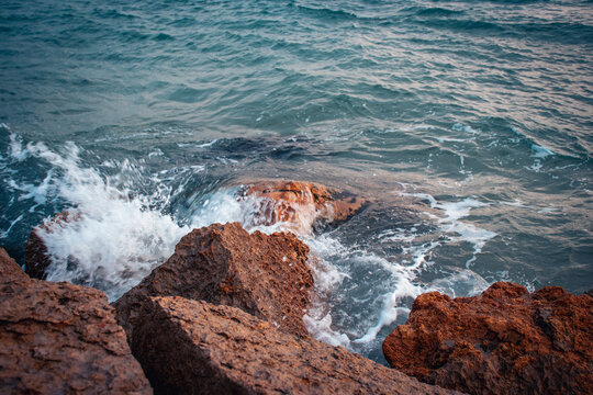 Seaside near Barcelona close up concept photo. Water with stones on the beach. Underwater rock.