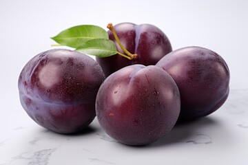  a group of plums sitting on top of a marble counter top with a green leaf on top of one of the plums and the plums on the other.