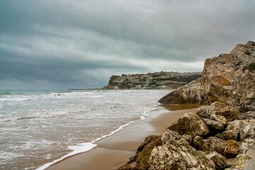 view of Peschici Bay and clifftop town under a rainy and overcast sky