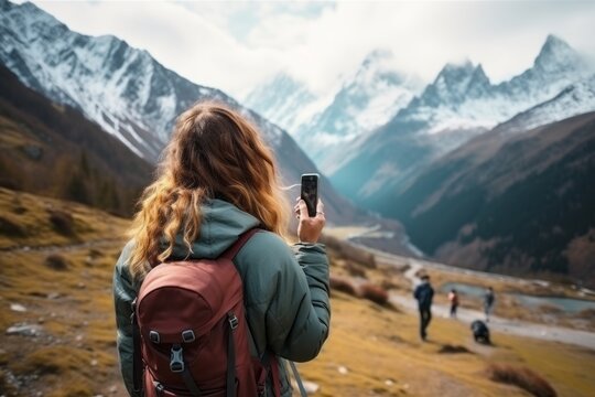 A young girl tourist takes a selfie against the backdrop of mountains