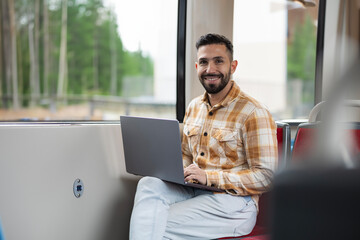 Hispanic entrepreneur looking at camera with his computer while heading to his office to work