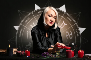 Female astrologer reading future on dark background