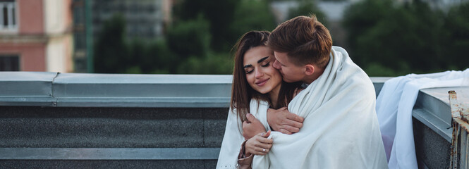 Beautiful young loving couple on a surprise romantic date on a roof top. Picturesque view,...