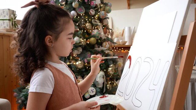 Little girl artist paints on drawing easel. Happy new year 2024. Art school.