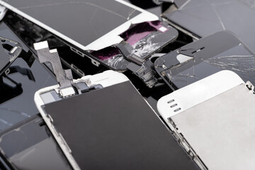 A heap of broken screens lying one on top of another, showcasing electronic devices prepared for...
