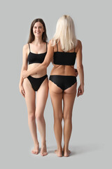 Body positive women in underwear on light background