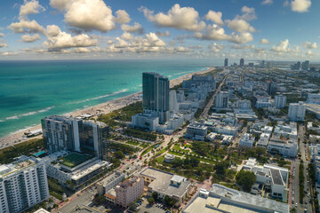 Travel destination in United States. South Beach sandy surface with tourists relaxing on hot Florida sun. Tourism infrastructure in southern USA. Miami Beach city with high luxury hotels and condos - obrazy, fototapety, plakaty