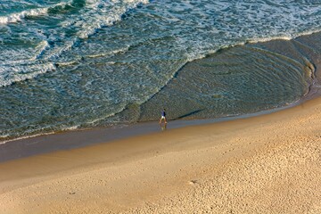 Rio de Janeiro, Brazil. Men walking on Copacabana beach in the morning