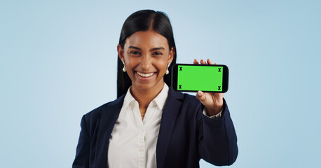 Happy business woman, phone and green screen for advertising against a blue studio background. Portrait of female person or employee smile showing mobile smartphone display, chromakey or mockup space