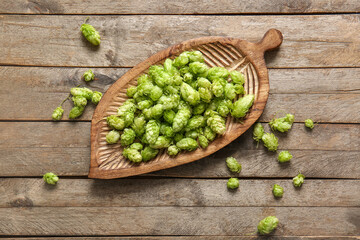 Board with fresh green hops on wooden background