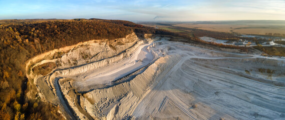Aerial view of open pit mining site of limestone materials for construction industry with excavators and dump trucks - obrazy, fototapety, plakaty