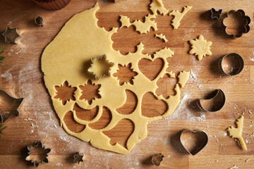 Rolled out pastry dough from which various shapes are being cut out