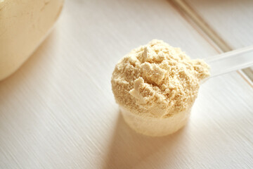 Whey protein powder in a plastic measuring cup