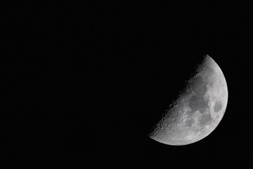 crescent moon photographed with a telescope. The moon is at 50% luminosity