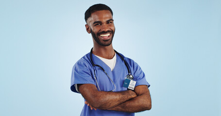 Happy man, portrait and professional doctor with arms crossed in medical care against a blue studio...