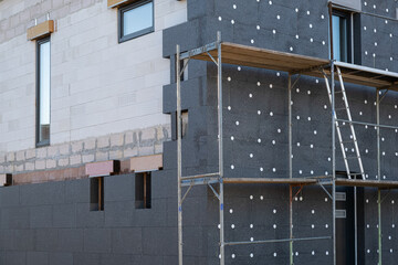New House building in process insulation of the wall of the house with layers of modern thermal...