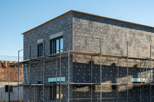 New House building in process insulation of the wall of the house with layers of modern thermal insulation materials . Exterior covering in construction site.