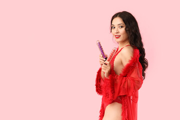 Beautiful young happy Asian woman in sexy underwear with vibrators on pink background - obrazy, fototapety, plakaty