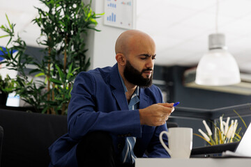 Start up business manager solving difficult problem using laptop while working in office. Thoughtful entrepreneur analyzing complex data and creating strategies for company development