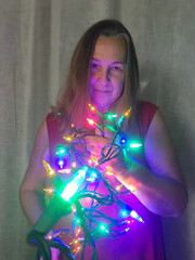 senior adult woman holding Christmas lights