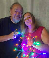 senior adult couple holding Christmas lights