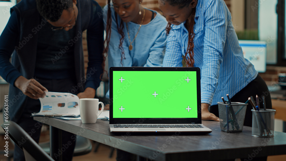 Aufkleber people using laptop with green screen on table, having isolated copyspace display in meeting to revi