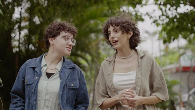 Duas mulheres conversando, caminhando no parque. Cinematico 4k.
