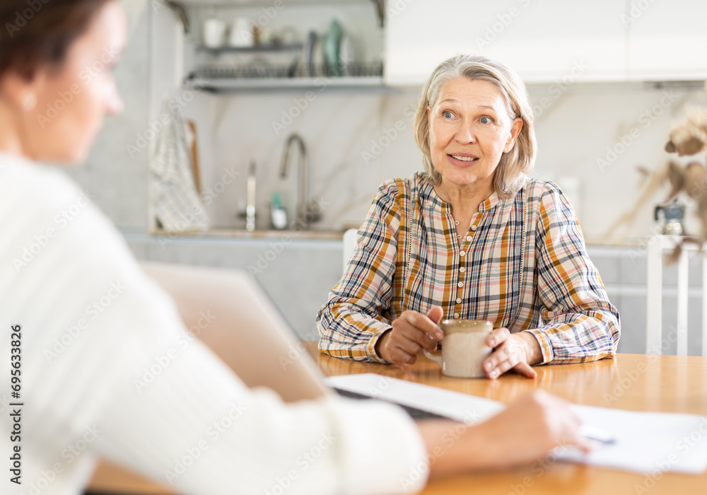 Wall mural real estate agent consulting elderly woman in home interior