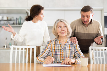 Old woman deciding and signing inheritance papers in family circle