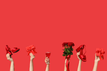 Female hands with bouquet of beautiful roses, high heels, cocktail glass and gift boxes on red...