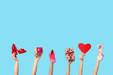 Female hands with gift boxes, stylish high heels and paper heart on blue background. Valentine's...