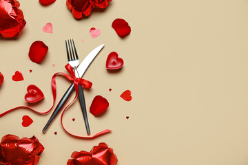 Beautiful cutlery for Valentine's Day with hearts, candles and balloons on beige background