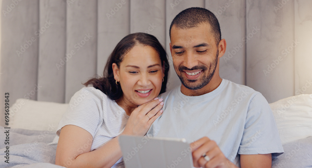 Sticker Tablet, happy and young couple in bed watching a video on social media or the internet together at home. Smile, digital technology and man and woman relaxing and bonding in bedroom at modern house.