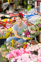 Fototapeta premium Female shopper chooses a chic bouquet of flowers at the flower market