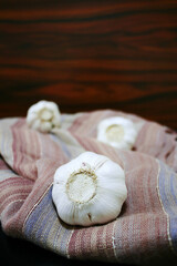 Closeup of garlic bulb. Garlics on the rustic fabric.