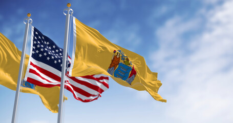 New Jersey state flags waving with the american flag on a clear day