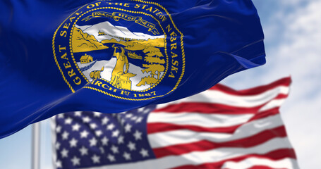 Nebraska state flag waving with the American flag in background - obrazy, fototapety, plakaty