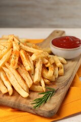 Delicious french fries served with sauce on white wooden table, closeup