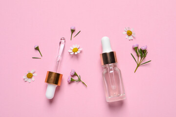 Bottle of cosmetic serum, pipette and beautiful flowers on pink background, flat lay