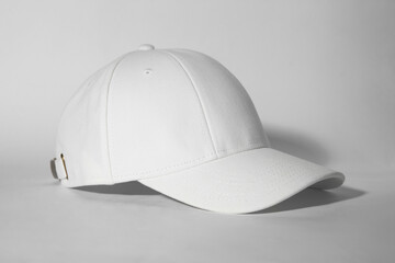 Stylish white baseball cap on light background
