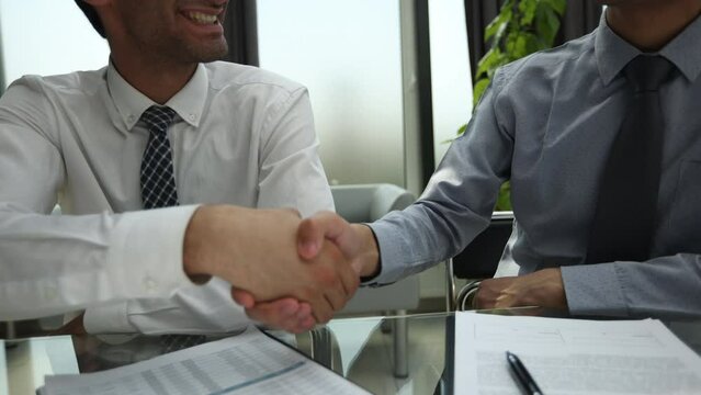 Business people signing contract papers while sitting at the glass table in office, closeup.